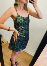 Vestido corto de lentejuelas tornasoladas con espalda baja y tirantes finos cruzados.