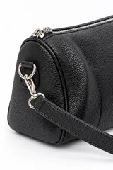 Cartera bandolera negra de formato cilíndrico, completamente cubierta de tachas plateadas en forma de corazón. Cuenta con cierre superior y correa ajustable.