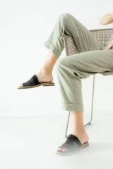 Sandalias planas de cuero marrón con tira ancha sobre el empeine. La plantilla es de cuero con la inscripción "LE".