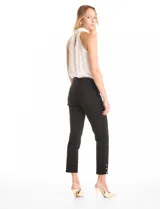 Pantalón de tiro alto con pretina elástica y silueta ajustada. Presenta un diseño tipo pull-on sin cierres, con aberturas laterales en el ruedo decoradas con tres botones metálicos dorados.