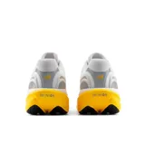 Championes de running New Balance modelo 1080 v15, de color blanco con detalles en amarillo y gris. Presentan capellada de malla transpirable, suela amortiguada en tono amarillo y el logotipo "N" característico en los laterales.
