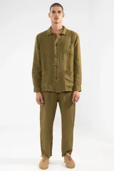 Pantalón de lino color verde oliva, de corte recto y fit relajado. Tiene cintura elástica con cordón de algodón, bolsillos laterales y bolsillo trasero.