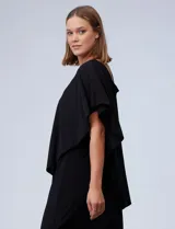 Vestido corto negro de RM Richards, con un hombro descubierto y una manga corta con volado. Presenta un aplique de lentejuelas plateadas en el tirante.