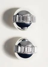Aros de clip plateados con diseño abombado y detalles texturizados de cristales incrustados en el centro.