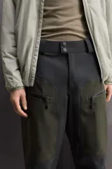 Pantalón deportivo técnico de esquí con tres capas y membrana impermeable. Presenta cintura ajustable, bolsillos frontales con cremalleras termoselladas, aberturas de ventilación laterales, bajos ajustables con refuerzos, polainas interiores y sistema de rescate RECCO integrado.
