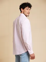 Camisa de corte regular fit, confeccionada en tejido oxford de algodón. Presenta cuello clásico, cierre frontal con botones y un bolsillo en el pecho.