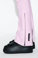 Pantalón de esquí rosa con corte flare, tiro alto, bolsillos frontales con cremallera y bajos con cremallera y aplicación de parche técnico.