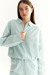 Buzo de corte oversized a rayas grises y blancas, con cuello polo y mangas largas con puños elásticos.