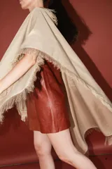 Chal de tejido liviano con terminaciones desflecadas en todo su contorno. Diseño versátil que permite diversas formas de uso.