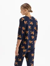 Remera de tejido flamé color azul marino con estampado de corazones con flechas en tonos marrones. Presenta cuello redondo y mangas tres cuartos con un corte holgado.