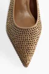 Zapato tipo slingback color tostado con punta fina, taco kitten y superficie completamente cubierta de strass brillante. Cuenta con una tira trasera elástica para mayor ajuste.