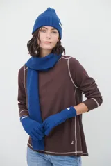 Remera de manga larga en color beige, confeccionada en tejido de punto con costuras a la vista en contraste. Presenta un corte holgado, cuello redondo y un pequeño bordado distintivo en la parte inferior.