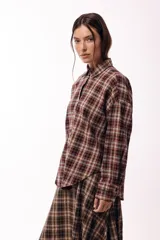 Camisa de manga larga con estampado de cuadros tartán en tonos marrones y beige, con cuello clásico y cierre frontal de botones.