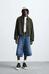 Cazadora de corte relajado confeccionada en tejido de algodón con efecto lavado. Presenta cuello solapa, cierre frontal con cremallera, bolsillos laterales en la cadera y mangas terminadas en puños con botón.