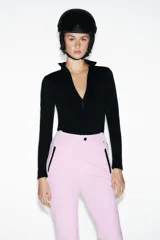 Pantalón de esquí rosa con corte flare, tiro alto, bolsillos frontales con cremallera y bajos con cremallera y aplicación de parche técnico.