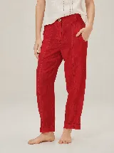 Pantalón de lino rojo con diseño estilo barrel, costuras decorativas pespunteadas en contraste, bolsillos delanteros y presillas para cinturón.