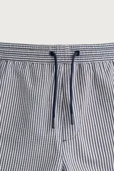 Short de baño confeccionado en tejido técnico con patrón de rayas verticales en tonos azul marino y blanco, con cintura elástica ajustable mediante cordón y bolsillos laterales.