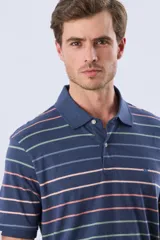 Remera polo de manga corta, color azul con diseño de rayas horizontales en tonos rosados, celestes y verdes. Cuenta con cuello clásico y tapeta con dos botones.