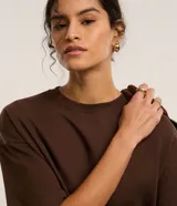 Blusa basica oversize de algodon color marron, con cuello redondo y mangas cortas con sisas desplazadas.