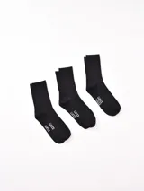 Pack de tres pares de medias negras de caña corta, con el logo "LUCCE" estampado en blanco en la planta del pie.