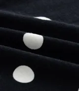 Blusa de cuello alto y manga larga, confeccionada en viscolycra con estampado de lunares blancos sobre fondo negro.