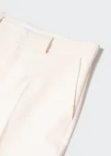 Pantalon de vestir de corte recto y tiro medio, confeccionado en tejido fluido. Presenta trabillas en la cintura, dos bolsillos laterales y dos bolsillos de ribete en la parte posterior.
