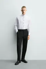 Camisa slim fit de algodón con cuello smoking, manga larga con puño doble para gemelos y pechera combinada a tono con cierre frontal de botones.