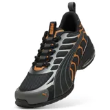 Championes Puma modelo Voltra, de diseño deportivo con tecnología X-CELL en la suela. Presentan una base de malla negra con detalles superpuestos en gris y naranja, incluyendo el logo de la marca en el frente.