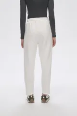 Pantalón tipo babucha de corte recto, confeccionado en tejido con felpa, con cintura elástica y cordón de ajuste frontal.