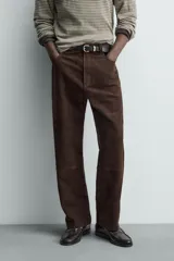 Pantalón de corte straight fit confeccionado en ante de color marrón, con diseño de cinco bolsillos y cierre frontal con cremallera y botón.
