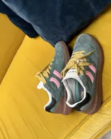 Championes Coolway modelo Goal, confeccionados en serraje verde con detalles en piel color rosa, marrón y negro. Presentan cordones planos color mostaza, suela de goma flexible y refuerzos con pespuntes en la puntera.