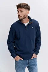Sudadera de cuello alto con cierre frontal parcial, de manga larga y diseño liso en color gris oscuro. Presenta un pequeño logo bordado en el pecho.
