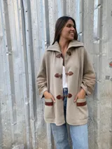 Saco capa color beige, tejido en lana con detalles de trenzas en cuello y puños.