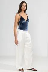 Pantalón de lino italiano color blanco con hilo metalizado, corte recto, talle medio, cintura elástica en la parte trasera y bolsillos delanteros.