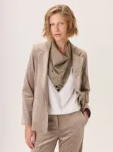 Blazer de mujer color beige, confeccionado en simil terciopelo con forro estampado. Presenta solapas clásicas y un corte estructurado.