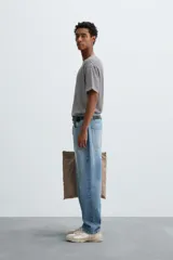 Camiseta de corte relajado con cuello redondo y manga corta, confeccionada en tejido de algodón y lino a rayas horizontales blancas y negras.