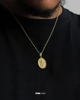 Collar dorado con cadena de eslabones finos y dije ovalado con diseño grabado.