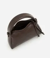 Cartera pequeña de diseño estructurado color marrón, con asa corta fija y correa larga desmontable. Cuenta con cierre superior de cremallera y detalle de tiras decorativas en el lateral.