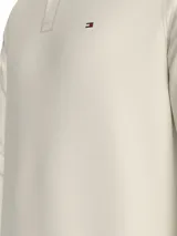 Chomba de manga larga Tommy Hilfiger confeccionada en puro algodón, con cuello clásico, cartera de dos botones y logo de la marca bordado en el pecho.