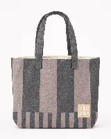 Bolso tipo tote con diseño de rayas verticales en tonos gris y marrón, con manijas largas y etiqueta con logo en la parte inferior.