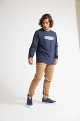 Remera de manga larga color azul marino, con cuello redondo y estampado frontal con el logo de la marca sobre un diseño de pincelada.