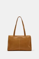 Bolso de hombro de piel color tostado, con detalle de costuras verticales pespunteadas en el cuerpo, doble asa de hombro y cierre con botones imantados.