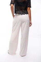 Pantalón de vestir color blanco, de corte palazzo y tiro alto.