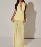 Vestido largo amarillo con escote halter pronunciado, fruncido en la cintura y falda con volados.