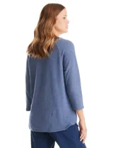 Buzo de tejido soft color azul, con cuello redondo y detalle de abertura tipo keyhole en el escote. Presenta mangas largas con sisa raglán y un ajuste holgado.