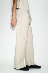 Pantalón de tiro medio confeccionado en tejido de punto elástico con pierna recta. Cuenta con cintura elástica ajustable mediante cordones y bolsillos laterales.