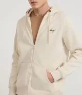 Saco masculino color beige, con capucha ajustable con cordón, cierre frontal por cremallera, manga larga con puños ajustados, bolsillo canguro y estampado lettering en el pecho.
