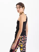 Top negro de un solo hombro con volados en el delantero.