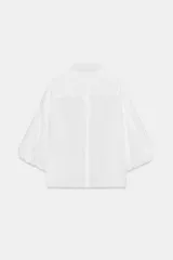 Camisa roja de cuello solapa, con mangas cortas abullonadas tipo globo y cierre frontal con botones ocultos.