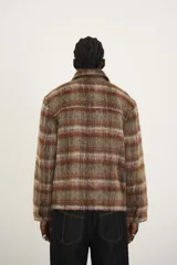 Sobrecamisa estilo chaqueta a cuadros color marrón, con cierre completo y cuello clásico. Incluye bolsillos de solapa en el pecho con detalles de remaches y tachuelas, y un corte ligeramente boxy.